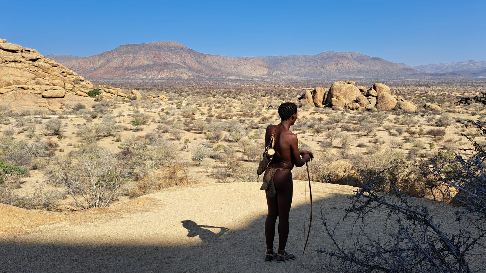 San tracker overlooking the Erongo plain — mountains behind