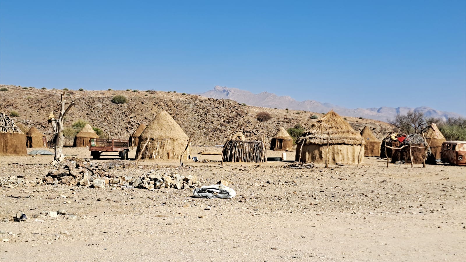 Himba settlement, Damaraland — thatched huts below the rocky hills