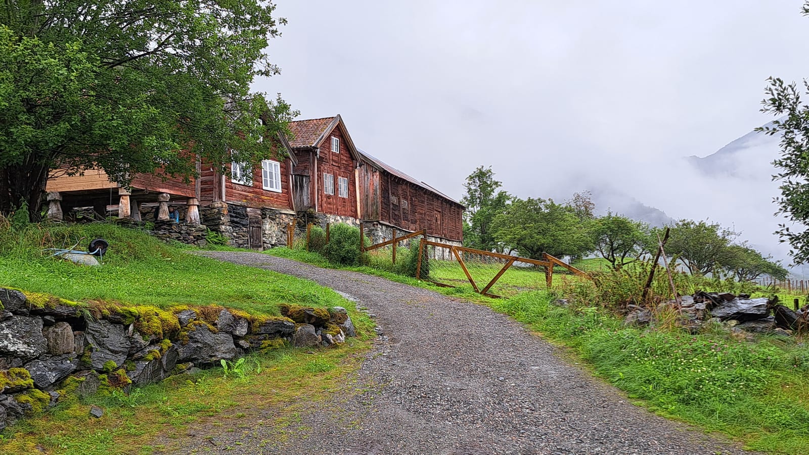 The log houses of Otternes Bygdetun, desolately empty under the heavy rain