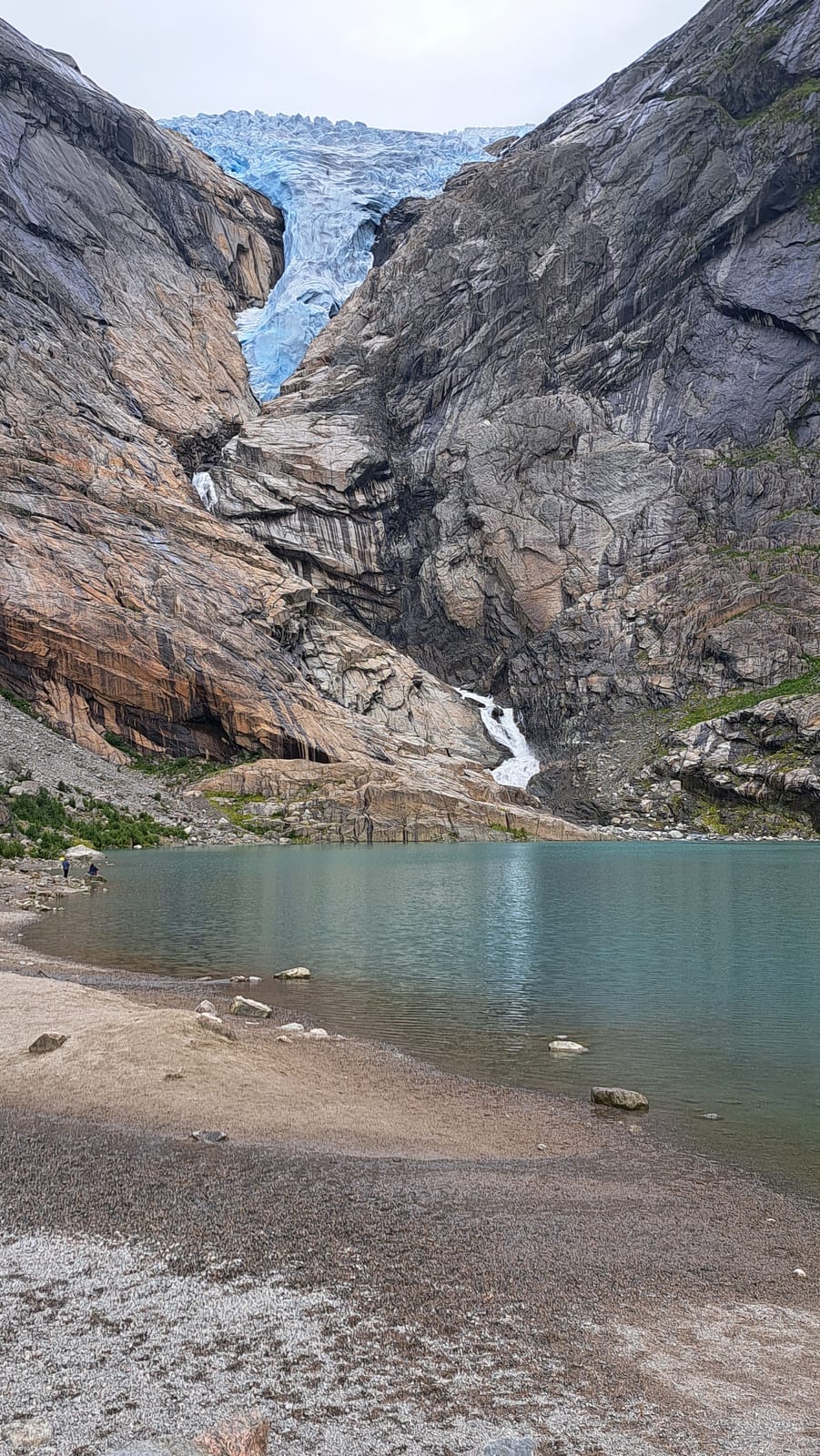 The tongue of the Briksdalsbreen glacier reaching down to the glacial lake, with Kleivafossen on the rock face