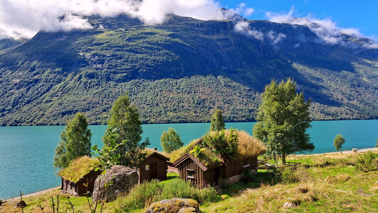 The turf-roofed wooden houses of Breng Seter, above the turquoise waters of Lovatnet