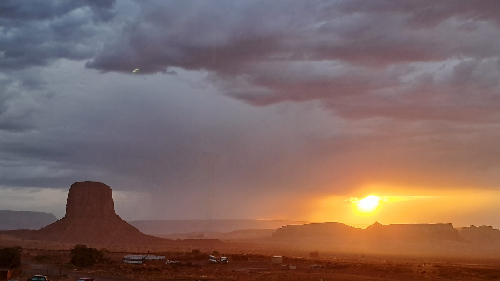Sunset breaking through a rare desert storm over Monument Valley